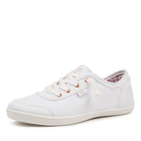 A white canvas low-top sneaker with white laces, rose gold eyelets, and a white rubber sole, shown from a side profile on a white background.