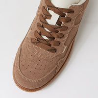 A close-up, top-down view of a brown suede sneaker with matching brown laces and a white collar, set against a clean white background.