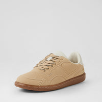 A low-top suede sneaker in beige with a brown gum sole, beige laces, and a cream collar, shown from a three-quarters angle on a light gray background.