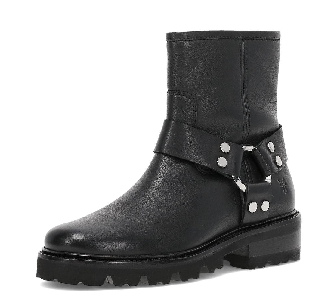 A black leather ankle boot with a chunky lug sole, a wide strap across the instep featuring silver studs and a buckle, and a small embroidered logo on the side, shown against a plain white background.
